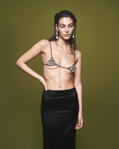 model wearing a tiny Gucci bra top with a black skirt 