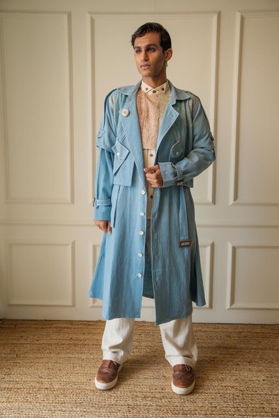 model wearing a demin trench coat with white pants and brown shoes