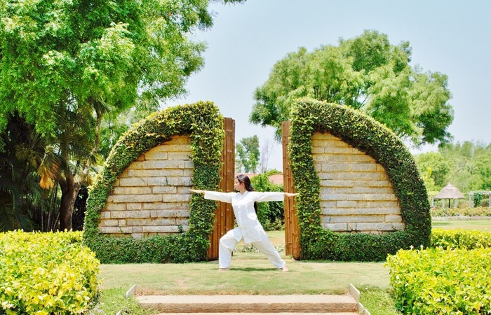 woman practicing yoga at soukya wellness resort in india 
